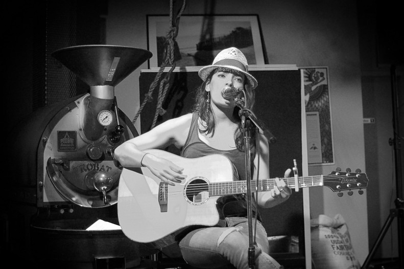 Samantha Jane at Trees Cafe, Vancouver, singing and playing guitar. Black and white image